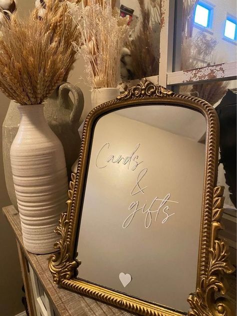 This mirror sign is a perfect addition to your classic/modern wedding reception!  The mirror comes with an easel that is attached to the back for easy displaying on a table top surface. The item has white vinyl lettering attached to the mirror's surface that can be removed after your event. Thank you for shopping small! We appreciate your business! If you are pleased with your item, please leave us a review!  Size:  11.8" L x 9.6" W Care:  When cleaning the mirror's surface, be sure to use a glass cleaner and microfiber cloth. Avoid the letters while wiping the glass clean.  Shipping:  Item will ship 5-10 days after placing your order. Cards And Gifts Mirror Sign, Oval Mirror Wedding Sign, Mirrors In Wedding Decor, Mirror Wedding Signs For Reception, Baby Shower Mirror Sign, Gold Mirror Wedding Sign, Mirror Wedding Signage, Mirror Bar Sign, Mirror Wedding Sign