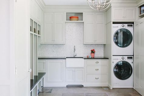 Cottage laundry room features light grey cabinets paired with black countertops and a mosaic marble tiled backsplash. Kitchenette With Laundry, Cottage Laundry Room, Laundry Room Baskets, Transitional Laundry Room, Laundry Room Paint Color, Grey Laundry Rooms, Laundry Room Storage Shelves, Laundry Room/mud Room, Light Gray Cabinets