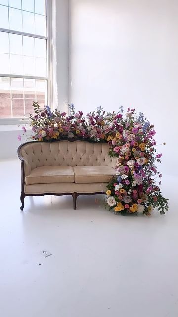 Sofa Flowers Wedding, Sofa With Flowers Wedding, Floral Couch Photoshoot, Couch Photo Op Wedding, Couch Floral Installation, Vintage Couch Backdrop, Wedding Expo Booth Ideas Floral Design, Flower Photo Op, Flower Back Drop Photoshoot