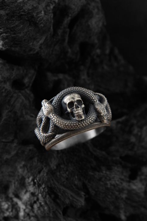 This silver skull and snake figure ring is a bold and edgy accessory that is sure to make a statement. The ring is made of sterling silver and features a detailed design of a skull with a snake wrapped around it. The intricate detailing on the ring makes it a standout piece that is perfect for anyone with a rebellious or rocker  inspired style. Wear it alone as a statement piece or pair it with other silver jewelry for a cohesive look. This ring is sure to become a favorite in your collection. F Gothic Accessories Jewellery, Bug Ring, Skull And Snake, Snake Skull, Silver Snake Ring, Gothic Mode, Edgy Accessories, Snake Ring Silver, Custom Ring Designs