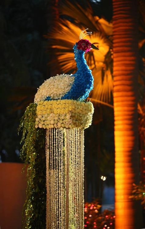 A gorgeous model of peacock made with flowers is adding a unique glamour to the wedding venue | wedding inspiration | wedfine.com | Peacock Theme Decor, Indian Wedding Decor, Wedding Hall Decorations, Peacock Theme, Desi Wedding Decor, Mandap Decor, Marriage Decoration, Mehndi Decor, Peacock Decor