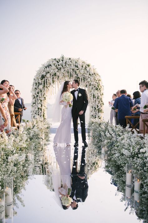 There are almost no words to describe this incredible destination wedding in Phuket. With a mirror walkway ending at a stunning white floral arch surrounded by the sea...these photos are out of this world! Wedding Aisle Mirror, Reflective Walkway Wedding, Mirrored Walkway Wedding, Mirror Ramp Walk Wedding, Mini Wedding Ceremony, Mirror Pathway Wedding, Mirror Isle Runner Wedding, All White Wedding Ceremony Decor, Mirror Isle For Wedding