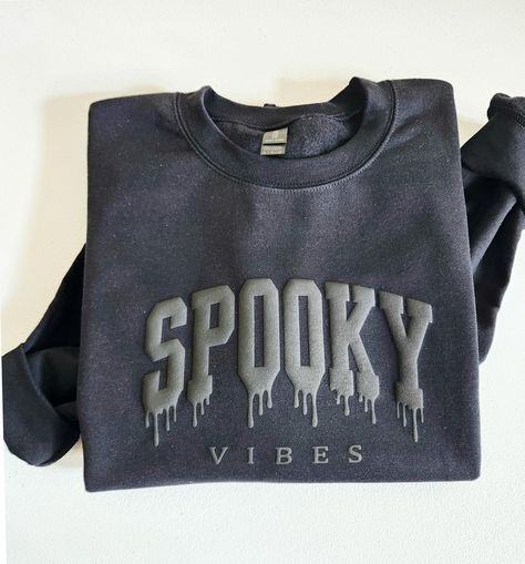 with this Spooky Vibes Puff Halloween Sweatshirt Get into the Halloween spirit  This crewneck shirt features embossed raised letters for a unique and festive look. The puff print design adds a fun texture to this spooky season shirt - making it a great gift for any Halloween enthusiast. Whether you're celebrating in style or just looking for a cute and cozy top to wear, this sweatshirt is sure to impress. PLEASE WRITE YOUR PUFF COLOR IN THE PERSONNALISATION BOX  Puff Colors : Black, Red, White, Puff Vinyl Shirts, Puff Vinyl Sweatshirt, Puff Vinyl, Halloween Apparel, Raised Letters, Cozy Tops, Puff Print, Festive Look, Spooky Vibes