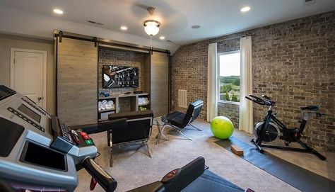 Industrial man cave and exercise room combo features workout equipment and yoga mats placed in front of exposed brick walls. Home Gyms Ideas Garage, Home Gym Office Combo, Basement Workout Room, Industrial Man Cave, Room Ideas Men, Home Gym/office, Workout Room Home, Media Room Design, Loft Bed Frame