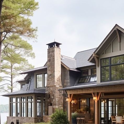 A grand luxury stone lake house with stone, siding, and detailed wood elements. A perfect blend of modern ranch and modern farmhouse style with black windows surrounded by beautiful outdoor living and gardens. Design: @windthekey Follow @windthekey for more design inspiration. Craftsman Lake House Interior, Oregon Lake House, Lake House Walkout Basement, Western Lake House, Colorado Lake House, Stone Lake House, Lake House Entryway Ideas, Lake House Exterior Colors, Modern Farmhouse Elevation