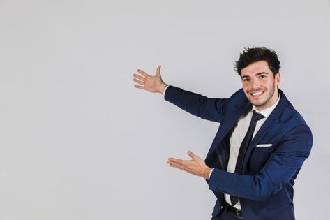 Happy portrait of a young businessman giving presentation against grey background | Premium Photo #Freepik #photo #background #business #invitation #people Workplace Quotes, Close Up Portraits, Poster Background Design, 웃긴 사진, Business Infographic, Gray Background, Free Photo, Pose Reference, Business Man