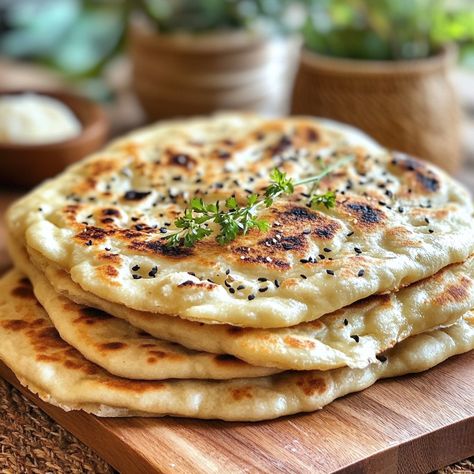 🍞 Plain and Cheese Naans: The Soft and Delicious Indian Flatbread You'll Love! 🧀 Ingredients: - 300 g flour - 1 teaspoon sugar - 1 teaspoon salt - 1/2 sachet baking powder - 1 plain yogurt (about 125 g) - 2 tablespoons olive oil - 100 ml warm water - 100 g grated cheese (mozzarella or emmental type) - A little melted butter for cooking Preparation: In a large bowl, mix the flour, sugar, salt and baking powder. Then add the plain yogurt and olive oil. Mix well to obtain a sandy dough. Gradual... Cheese Naan, Indian Flatbread, Cheese Mozzarella, Oil Mix, Plain Yogurt, Grated Cheese, Flatbread, Large Bowl, Melted Butter