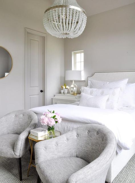 Elegant gray and white bedroom features gray tufted accent chairs placed in front of a white French bed on either side of a Bertram 16" Mirrored Side Table lit by a Currey & Co Chanteuse Chandelier. Elevated Apartment, All White Bedroom, Guest Bedroom Design, Bedroom Reveal, Spring Refresh, Guest Bedroom Decor, Bedroom White, Cottage Exterior, Bedroom Style