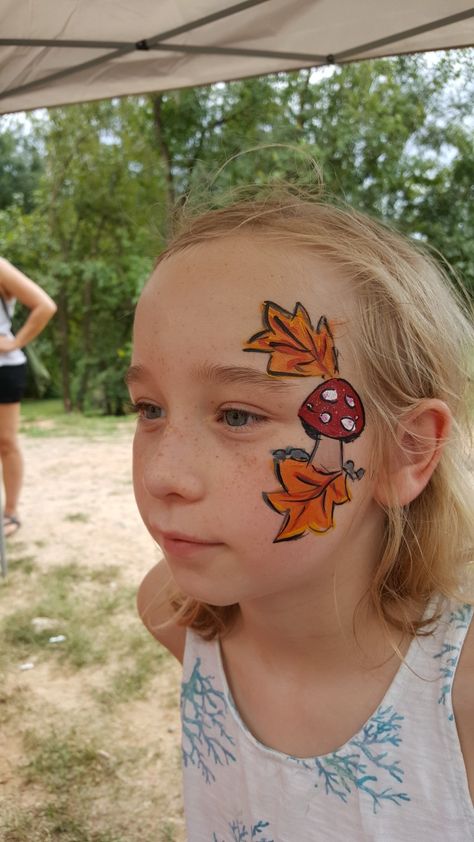 Mushroom face paint Fall Cheek Face Painting, Face Painting Ideas For Fall Festival, Woodland Face Paint, Fall Fest Face Painting, Harvest Festival Face Painting, Face Painting Mushroom, Easy Fall Festival Face Painting Ideas, Woodland Fairy Face Paint, Fall Leaves Face Paint