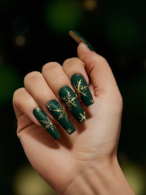 Matte forest green nails are adorned with stunning golden snowflakes, creating a festive and luxurious design. This look is perfect for the holiday season with its rich tones and intricate winter detailing. Christmas Nails Forest Green, Matte Green And Gold Christmas Nails, December Nails Green And Gold, Forest Green Gold Nails, Christmas Green And Gold Nails, Winter Christmas Nails Green, Dark Green Xmas Nails, Forest Green Nails Christmas, Golden Green Nails