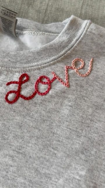 Diy Clothing Embroidery Courses | Hand Embroidery Kits on Instagram: "Happy #SIPsunday! SIPsunday means Stitch in Progress Sunday and it’s a promise to spend at least 30 minutes a week on a fun embroidery project, sippin on something you love and enjoying some quiet me time! This week I made a Valentine’s Day sweatshirt. I plan to add some hearts sometime this week, or maybe my boys names on the sleeve! What are you stitching on this week? Also.. should I make this neckline love design a pattern?! Let me know🩷❣️ Looking to learn how to do this? Check out my page for more information about my beginner clothing embroidery course!" Name Embroidery On Tshirt, Hand Stitching Sweatshirt, Hand Embroidery Valentines Day, Heart Embroidery Sweatshirt, Embroidery Tshirt Designs, Hand Embroidery Beginner, Valentine Embroidery Ideas, Hand Embroidery On Sweatshirts, Diy Embroidery Sweatshirt