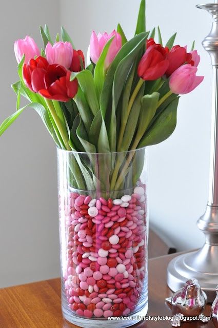 Centerpiece for a Valentine's tablescape. Tulip and valentine M's vase - place a smaller glass vase inside a larger one. Fill the gap with M & M's. Valentine Tablescape, Saint Valentin Diy, Valentines Bricolage, Flowers For Valentines Day, Valentine Centerpieces, Valentinstag Party, Small Glass Vases, Valentines Flowers, Valentine's Day Quotes