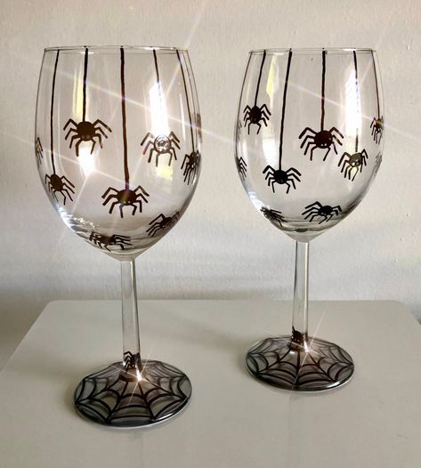 Happy Spooky Season!! This creepy crawly wine glass includes Hand Painted spiders! There are 8 spiders on webs and a few more below them on these MADE TO ORDER glasses. The spiders cover one half of the glass. Each spider has been detailed with 8 little legs and a set of two eyes (there should be 6.. but that's okay!). These spiders are descending from the top of the glass and on their way back to their spiderweb below! Depending on which glass style you choose, you will see a spiderweb on the bottom of your glass. These glasses are the perfect gift for any lover of spooky things, spiders, or Halloween fun!  I also offer several other Fall/Halloween designs. Please contact me if you would like to mix and match a SET of Glasses with others in my shop. I would be happy to create a "private l Halloween Diy Wine Glasses, Halloween Cup Painting Ideas, Glass Halloween Decor, Halloween Glass Painting Ideas, Spooky Wine Glasses, Halloween Wine Glasses Diy Painted, Halloween Shot Glasses Diy, Halloween Painted Glasses, Wine Glass Painting Ideas Halloween