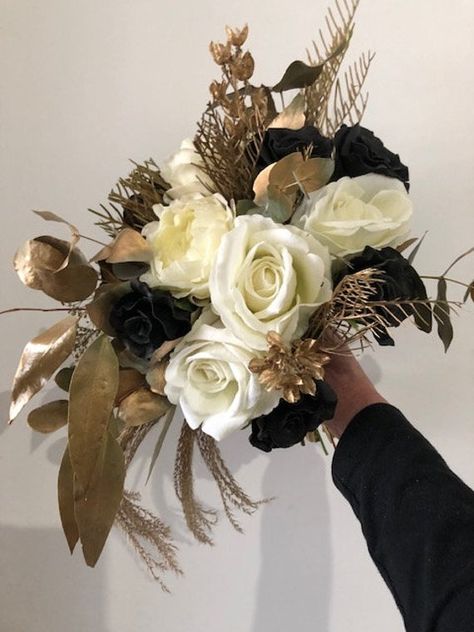 If your theme is gold and you are not superstitious about black, then this is a gorgeous, simple unstructured yet round bouquet for you.  This bouquet is high end quality  black roses, cream latex David Austin, realistic roses, dried and sprayed gum leaves, grevillea &  sprayed in a gorgeous gold.  This listing is for 1 Bridal bouquet and 1 Groom button hole. See one of our beautiful Brides, Jayme who ordered this gorgeous creation.  I can custom order to suit, simply send me a message. For over Gold Wedding Flowers, Black Bouquet, Gold Bouquet, Black And Gold Theme, Gum Leaves, Black And White Wedding Theme, Round Bouquet, Black Gold Wedding, White Wedding Theme