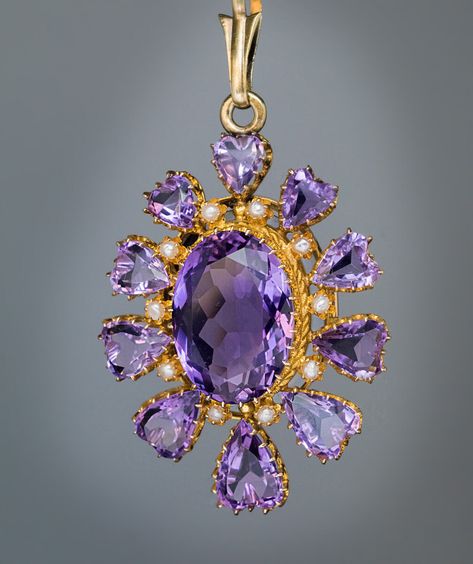 Antique Victorian Amethyst Gold Locket Pendant Ref: 275482 Click on Images to Enlarge Circa 1870s-1880s This vibrant antique 14K gold pendant features sparkling lavender purple amethysts. It is centered with an oval amethyst, accented by small half pearls, and  surrounded by ten heart-shaped amethysts which graduate vertically in size. The back of the pendant is fitted with a glazed miniature picture compartment. Marked with Austro-Hungarian fox head assay mark, “H” for the city of Bergen, Pretty Jewelry Necklaces, Jewelry Purple, Austro Hungarian, Fox Head, Faberge Eggs, Gold Locket, Amethyst Gold, Amethyst Jewelry, Victorian Jewelry