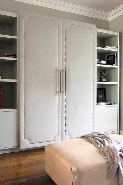 Walk-in closet features a wall lined with cabinet fitted with gray fabric paneled doors with silver nailhead trim flanked by gray shelves and cabinets. Contemporary Closet, Interior Design London, Modern Townhouse, Bedroom Cabinets, Closet Decor, Door Shelves, غرفة ملابس, Closet Door, Bespoke Interiors