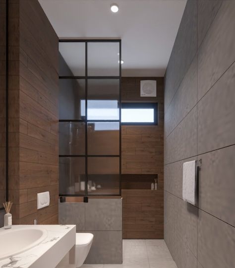 This stunning small bathroom design has a very modern yet minimalist vibe. A tall mirror is mounted on the wall and is accompanied by a small vanity. The shower area has been cleverly separated from the rest of the space by a glass partition, resting on a small wall, acting as a barrier. The shower area features a narrow yet wide niche, which is perfect for storing shower products, adding to the functionality of the space. Shower Area Glass Partition, Bathroom Shower Partition Wall, Bathroom Glass Partition Ideas, Narrow Bathroom Design Ideas, Small Bathroom Partition Ideas, Small Toilet Design Modern Minimalist, Bathroom Partition Glass Design, Washroom Glass Partition, Rest Room Design Bathroom