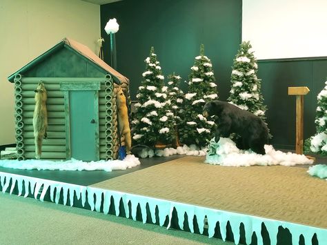 We made this log cabin for Operation Arctic VBS at our church. Used Christmas trees and a stuffed black bear for the stage. Operation Arctic Vbs Decorations, Arctic Vbs Decorations, Camp Firelight Vbs, Alaska Vbs, Operation Arctic Vbs, Kids Camp Activities, Arctic Vbs, Log Cabin Lighting, Christmas Cabin Decor