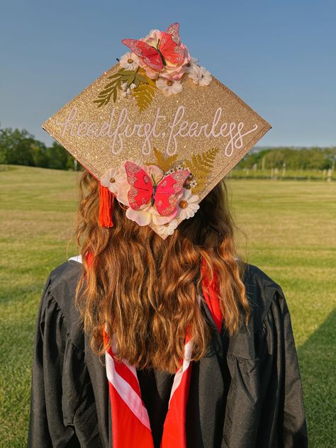 graduation cap with gold glitter background, flowers, pink butterflies, and white cursive that reads “headfirst, fearless” Disco Ball Graduation Cap, Senior Cap Ideas Taylor Swift, Glittery Graduation Cap Ideas, Paramore Graduation Cap, Taylor Graduation Cap, Taylor Swift Themed Graduation Cap, Taylor Swift Graduation Quotes, Grad Cap Inspo Taylor Swift, Taylor Swift Grad Cap Ideas