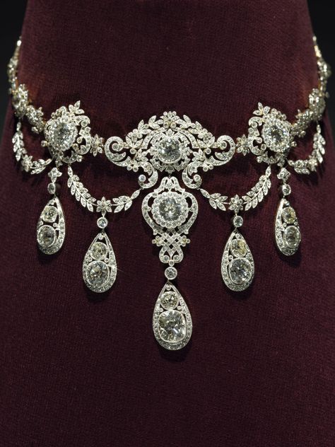 Wade Necklace, c. 1900, Tiffany & Co Gold, platinum, diamonds 36 x 8.5 cm. The diamond necklace features large, impressive stones that were made more readily available in the late 1800s by the opening of the vast diamond mines in South Africa. Tiffany’s designer contrasted pendants of the largest diamonds with delicate garlands of tiny stones to create an especially lavish array of brilliance around the neck Edwardian Jewelry, Tiffany Jewelry, Royal Jewels, Jewelry Lookbook, Royal Jewelry, Fancy Jewelry, Fabulous Jewelry, Fantasy Jewelry, Dream Jewelry