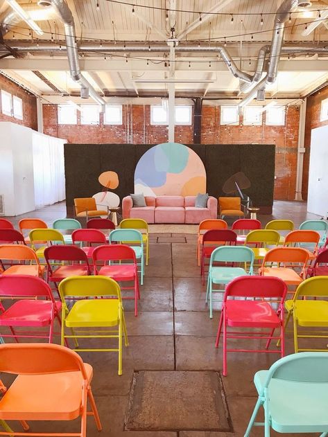 Bright and bold colorful folding chairs in a minimal, industrial event space Womens Conference Stage Design Backdrop Ideas, Colorful Stage Design, Production Studio Aesthetic, Colourful Portfolio, Pop Up Event Ideas, Conference Decor, Sp Studio, Event Space Design, Corporate Event Design