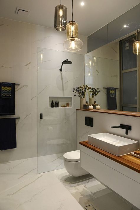 White marble wall tiles in bathroom / wood shelf and wood bench in bathroom / glass pendant lights in bathroom / Laufen basin #interiordesing #bathroominteriors #moderninteriordesign Design Interior Baie, Bathroom Wood Shelves, Modern Bathroom Lighting, Bathroom Pendant Lighting, Decor Baie, Glass Bathroom, Contemporary Bathrooms, Wood Bathroom, Bathroom Layout