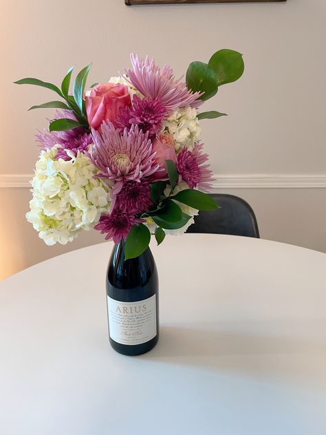 Centerpiece Wine Bottle, Flower Arrangement On Top Of Wine Bottle, Wine With Flowers On Top, Flower Bouquet With Wine Bottle, Flower Bouquet On Wine Bottle, Champagne Bottle Flowers Bouquet, Wine Bottle Floral Bouquet, Wine Floral Arrangements, Floral Wine Bottle