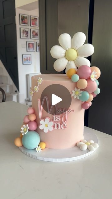 Claire Lawrence Cake Design on Instagram: "Cute Daisy themed cake for Maya’s first birthday 🥰 

Acrylic charm: @rowanandcocreative 
Colours: @cocoa.colour 
Board: @olbaa_cake_box 
Sugarpaste: @couturesugarpaste 

#cakedecorating #cakereels #cakevideos #daisycake #firstbirthdaycake #caketutorials #kentcakes #londoncakes #cakedesign" Colourful First Birthday Cake, First Birthday Cake Daisy, Cake Designs For First Birthday, Daisy Themed Birthday Cake, 1st Birthday Girl Cake Ideas, First Birthday Cake Buttercream, Toddler Girl Birthday Cake, Daisy First Birthday Cake, Daisy Themed Cake