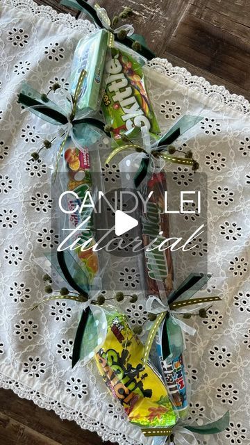 Jennifer Bryant on Instagram: "🎓 DIY Candy Lei Tutorial for Graduation Gifts! 🍬🌺  Our Polynesian friends have this adorable tradition of candy and floral leis, and because I almost got canceled last year on the tiktok for sharing this 😆 I got the go ahead from them to create and share with all of you!  I’m giving you the alternate instructions in case you can’t find plastic tubing! Try party supply stores and Amazon! You need 2 yards  Step 1: Gather your supplies - assorted candy (I use six), plastic wrap, ribbon, scissors. (You’ll need about two yards of the thinnest ribbon and one yard of each of the accents)  Step 2: Start by cutting the plastic wrap into a long strip. Lay out candies along the strip, leaving space between each. Alternatively use the tubing and simply slide the cand Candy Lays For Graduation, Candy Ribbon, Candy Lei Ideas, How To Make Candy Leis, Candy Leis For Graduation Diy For Boys, How To Make A Candy Lei, Candy Leis For Senior Night, Money Lays For Graduation Diy, Diy Senior Gifts