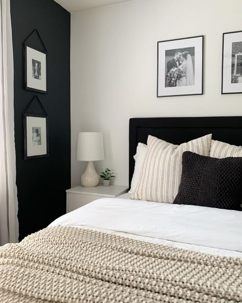 This bedroom features a black headboard bed with white, beige and black bedding. A beige bedroom lamp with white lampshade is placed next to the bed on a light gray bedside table. Black Furniture White Room, Black And White Bedside Lamp, How To Decorate A Bedroom With Black Furniture, Light Grey Black And White Bedroom, Black And Bedroom Ideas, Black Bed Beige Bedding, Black Bed Headboard Bedroom Designs, Black White Beige Bed, Black Gray Beige Bedroom