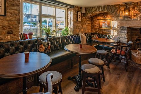 Pub seating area with stone walls, black fixed seating along one side with low stools and wooden tables. Ladies Toilet, Pub Interior, Cosy Bedroom, Pub Design, Open Fires, Banquette Seating, Home Bar, Architectural Features, Stone Wall