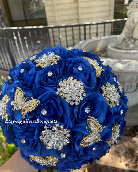 This beautiful bouquet is handmade with royal blue roses and with sparkling gold butterflies and brooches. The design can be change if requested. I can do it in different colors. Please message me the color. I also have the gold brooches.  *This bouquet is 10 inches in diameter* Please contact me with any questions! :) Brindis Quinceanera Royal Blue, Royal Blue Quinceanera Ideas, Royal Blue Wedding Dress, Royal Blue Quinceanera Theme, Royal Blue And Gold Quinceanera, Blue Quinceanera Ideas, Quince Accessories, Bouquet Royal Blue, Quince Bouquet