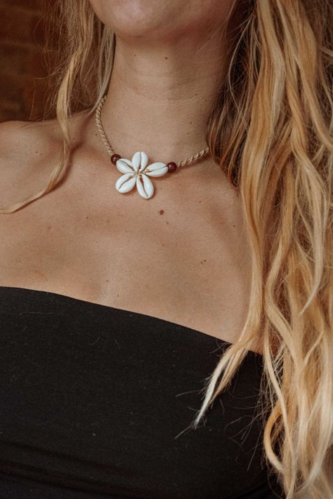 Elevate your beach style with our Surf Flower Macrame Shell Necklace, exclusively at Gardenbelle Shop. This gorgeous surfer-inspired necklace is crafted with real shells, a wooden bead, and intricately hand-tied cotton jute macrame. Designed to rest at a super flattering length of 15", it effortlessly adds a touch of bohemian charm to any outfit. Perfect for free spirits and beach lovers alike, this unique piece embodies our commitment to offering handmade, quality items. Embrace the ocean vibes and enhance your jewelry collection with this exquisite necklace. Sea Shell Choker Necklace, Puka Shell Necklace Outfit, Macrame Beaded Necklace, Coastal Jewelry Diy, Beachy Jewelry Diy, Shell Necklace Outfit, Beach Necklace Aesthetic, Gardenbelle Shop, Beach Accessories Jewelry