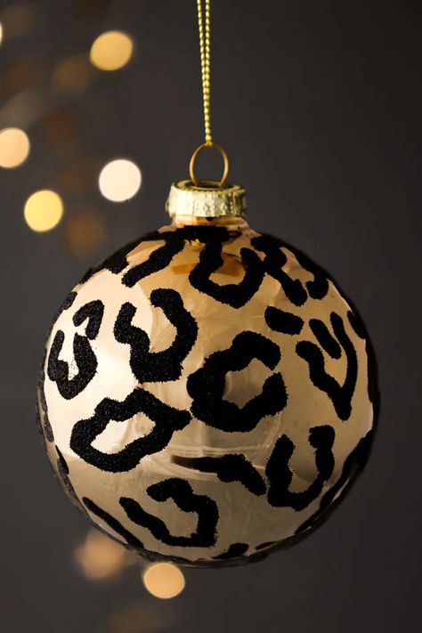 Christmas tree decoration of a gold sphere with black leopard print, hanging on a gold string. Animal Print Furniture, Black Christmas Tree Decorations, Black Gold Christmas, African Christmas, Christmas Trimmings, Gold Christmas Tree Decorations, Leopard Christmas, Rockett St George, Gold Christmas Decorations