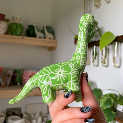 Guys!! I painted a little green sgraffito floral dinosaur! ✨🎨🦕What do we think of this design?? 🥰 what other Dino designs would you like to see? This little fella is now down in @collectivelymadewells waiting to find his forever home! ✨🏡 Check out my website to see all of my available ceramics for sale, link in bio ✨😘 #art #artist #ceramics #pottery #painting #illustrator #ceramicstudio #potterytiktok #potterypainting #painter #potteryart #ceramicpainter #floral #bisqueware #glaze #trinke... Ceramic Dinosaur Painting Ideas, Painting Bowls, Floral Dinosaur, Bio Art, Clay Stuff, Ceramics Projects, Ceramics Pottery, Illustrators On Instagram, Ceramic Studio