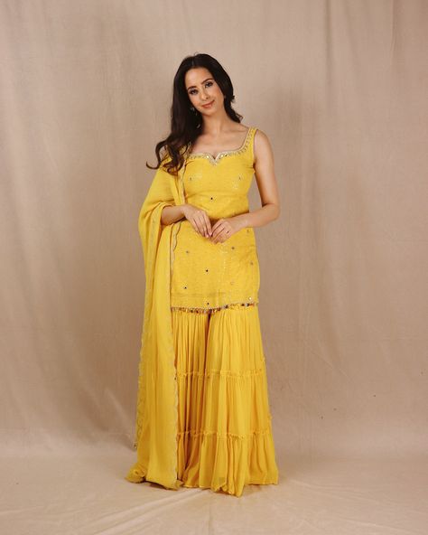 Introducing “Genda Phool”. The perfect sunshine yellow color to wear on your BFF’s Haldi. This stunning yellow kurta is crafted from crepe georgette with a luxurious 3-layered sharara. Adorned with intricate handwoven mirrors on the neckline and throughout the shirt, it features a beautifully handworked dupatta with colored tassels for a perfect finish. Shop our collection now. DM or email to book an appointment. #haldioutfit #haldidress #yellowsuit #shararadesign #shararasuits #shararad... Yellow Organza Sharara, Haldi Ceremony Outfit For Women, Yellow Kurta Woman, Yellow Kurti Design For Haldi, Yellow Sharara For Haldi, Haldi Ceremony Outfit For Sister Indian, Haldi Ceremony Outfit For Sister, Yellow Dress For Haldi Function, Dress For Haldi Function