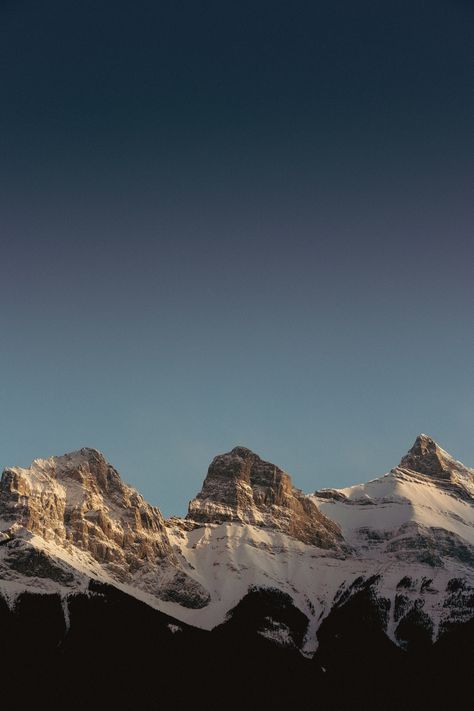 Behold the majestic beauty of the Three Sisters Mountains with this stunning digital download of a photograph taken in Canmore, Alberta. With their rugged peaks and snow-capped summits, the Three Sisters stand tall and proud, a testament to the raw power and awe-inspiring beauty of the Canadian Rockies. In this photograph, the mountains are bathed in the soft, warm light of the setting sun, casting a warm glow over the landscape and creating a sense of peace and tranquility that is truly captiva Alberta Banff, Canada Landscape, Photography Minimalist, Canmore Alberta, The Three Sisters, Mountains Sunset, Park Pictures, Minimalist Wall Decor, Sunset Landscape