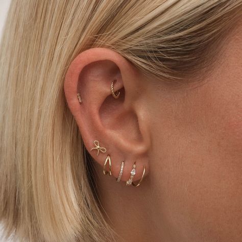 Elevate your ear game with Charlie's rope hoop mini clicker piercing. This delicate and charming earring adds a modern twist on a classic design, creating the illusion of gently winding through your lobes. Perfect for everyday wear and crafted in solid 14 karat gold, it's a must-have for any earring collection. Classy Ear Stack, Delicate Piercings Ear, 4 Piercings In Ear Lobe, Ear Inspo Jewelry, Minimalistic Ear Piercings, Earring Piercing Chart, 4 Ear Piercings In A Row, Minimalist Ear Piercings Simple Classy, Ear Perching