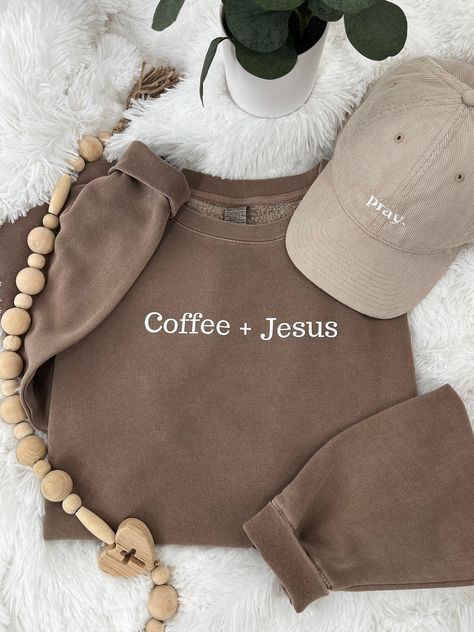 Coffee + Jesus Premium sweatshirt perfect for those chilly mornings and evenings.  Our sweatshirt is great for Christian women and men that love both coffee and Jesus.  Size up for oversize fit.  Coffee Brown Premium Sweatshirt: Female model wearing sweatshirt 5'10" 185 lb 9 oz./yd² (US) 15 oz./L yd (CA), 80/20 cotton/polyester blend with 100% cotton face, 30 singles Standard fit Split stitch double needle sewing on all seams Twill neck tape 1 x 1 ribbing at neck, cuffs and waistband Woven label Made To Worship Sweatshirt, Saying Sweatshirts, T Shirt Over Sweatshirt Outfit, Neutral Wardrobe Aesthetic, Christian Boutique Ideas, Bible Verse Sweatshirts, Christian Sweatshirts For Women, Cute Christian Sweatshirts, Sweatshirt Designs Vinyl