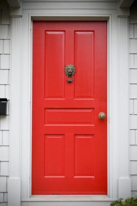 Off-white molding and framing support this bright red door, which has five rectangular panels and features a bronze doorknocker and a bronze doorknob. A black mailbox fixed to the wall is placed at the left side of the door. Red Door House, Vinyl Door, Red Doors, House Porch, Red Front Door, Exterior Stairs, Door Paint Colors, Front Door Porch, Front Door Entrance