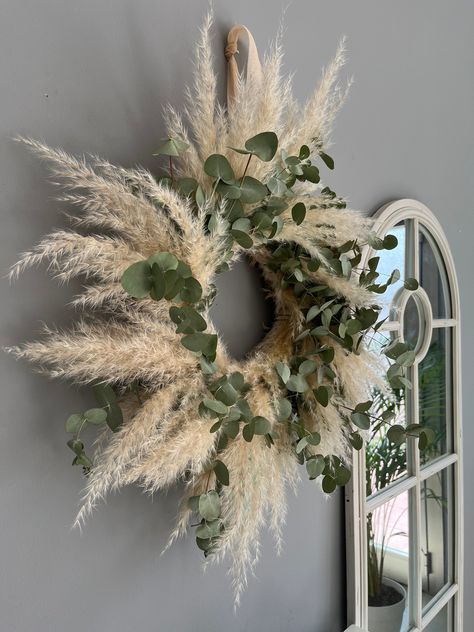 The Natural Boho wreath is for indoor use only. It is made up of natural fresh eucalyptus (will naturally dry with time), and pampas grass, and it has an original eucalyptus scent. It is an eco-friendly, eye-catching detail for your home and makes a perfect gift for your loved ones as well. All materials used are durable, so you will undoubtedly enjoy this wall decor for a few seasons. The diameter of the wreath is around 22”/55cm. The straw base hoop is 16"/36cm. *The colors on your display may Boho Winter Wreath, Pampas Deco, Pampas Grass Wall Decor, Pampas Wall Decor, Pampas Wall, Pampas Wreath, Pampas Grass Wreath, Eucalyptus Scent, Farmhouse Fireplace Decor