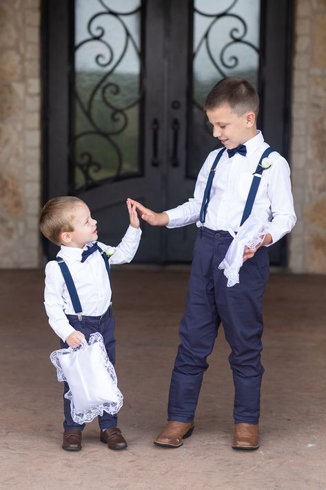 | summer wedding ring bearer outfits | ring bearers in navy blue pants, suspenders, + a bow tie | ring bearers in a navy blue bow tie + suspenders | white ring bearer boutonnieres | cute ring bearer photo ideas | dfw wedding | photo taken at THE SPRINGS Event Venue. follow this pin to our website for more information, or to book your free tour! SPRINGS location: Tuscany Hill in McKinney, TX photographer: Michelle Rice Photography #ringbearers #weddingstyle #summerwedding #weddingphotography #dfw Navy Blue Ring Bearer Outfit, Ring Bearer Navy, Ring Bearer Outfit Navy, Ring Bearer Boutonniere, Outfits With Suspenders, Ring Bearer Outfits, Wedding Ring Bearer Outfit, Navy Blue Bow Tie, Navy Rings