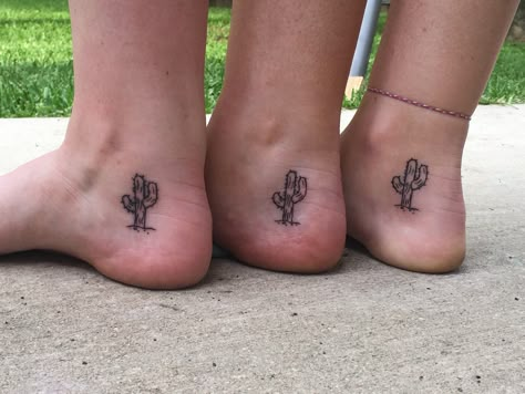 3 women’s inner ankles. There is a  saguaro cactus with some spines on it, with a line as the dirt and a couple small pebbles beneath. Small Western Ankle Tattoo, Western Sibling Tattoos, Cactus Tattoo Ankle, Dainty Cactus Tattoo, Inner Foot Tattoo, Small Arizona Tattoo, J A Tattoo, Little Cactus Tattoo, Cacti Tattoos