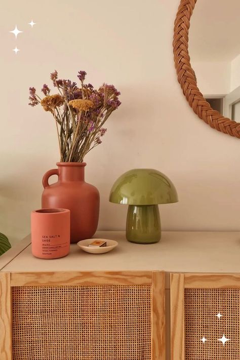 A neutral rattan cabinet styled with terracotta vase, dried florals, a scented candle, and green mushroom lamp Mushroom Bedroom, Mushroom Lamps, Boho Lamp, The It Girl, Diy Ikea, Lampe Decoration, Apartment Aesthetic, Retro Lamp, Cottagecore Decor