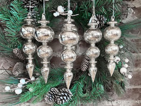 PRICES MAY VARY. Set of Six ornaments Each ornament measures 8.5-inch long Hand made & hand blown glass items, silvered on the inside of the glass as is traditional Silver color with subtle warm champagne tones for a vintage look Christmas Ornaments & Holiday Collectibles Made With only Quality Materials Keepsakes to delight for years to come! Mercury Glass Finial Christmas Ornaments Set of Six Silver Large Hanging Christmas Finials for Christmas Tree Decoration Holiday Décor. Box set of 6 Vinta Silver And Brown Christmas Tree, Large Christmas Tree Decorations, Silver Ornaments Christmas Tree, Champagne Christmas Decor, Christmas Finials, Vintage Christmas Decorations 1950s, Raz Imports Christmas, Elegant Christmas Tree Decorations, Mercury Glass Christmas Tree