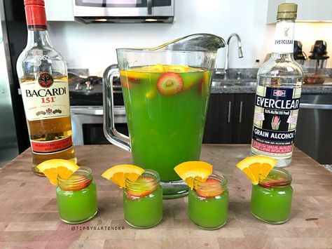 Green Jungle Juice - For more delicious recipes and drinks, visit us here: www.TopShelfPours.com Green Jungle Juice, Green Jungle Juice Recipe, Tipsy Bartender Jungle Juice, Alcoholic Jungle Juice, Green Alcoholic Drinks, Bacardi 151, Jungle Juice Recipe, Juice Shots, Halloween Juice