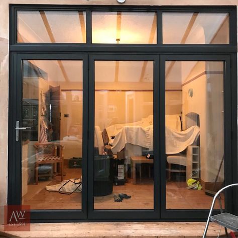 Grey aluminium bifold doors with fanlight Bifold Doors With Windows, Black Aluminium Bifold Doors, Crittal Doors Extension, Container Clinic, Bifold Exterior Doors, Disco Kitchen, Bifold Doors Onto Patio, Conservatory Lounge, Extension Exterior