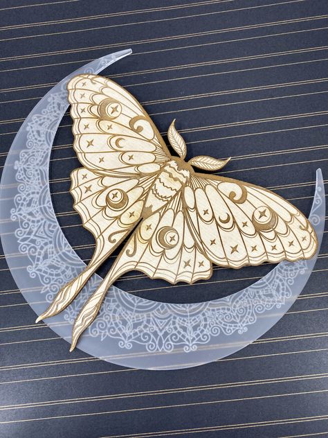 A graceful figure to land upon your walls, this luna moth sign is made from frosted acrylic and baltic birch. Engraved with moons and mendhi, this is the perfect addition to any home. Luna moth signs are ready to hang with attached hardware, and measure approximately 10 inches square.   Designed by Craft Genesis, made by us at The Evergreen Burrow Luna Moth Design, Lunar Moth And Moon Tattoo, Lunar Moth Line Art, Luna Moth Floral Tattoo, Lunar Moth Design, Chinese Moon Moth Drawing, Luna Moth Decor, Luna Moth And Moon Tattoo, Tattoo Luna Moth