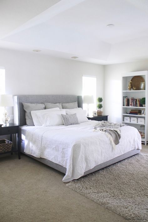 White bedroom with gray upholstered bed and large black nightstands Grey Upholstered Bed Bedroom, Upholstered Bed Bedroom, Gray Upholstered Bed, Grey Upholstered Bed, Grey Bed Frame, Bedroom Wall Designs, Up House, Couple Bedroom, Trendy Bedroom