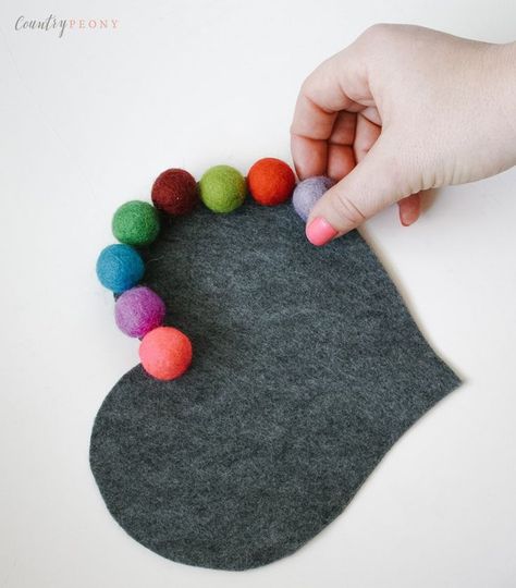 DIY Felt Ball Heart Trivet. A beautiful handmade gift idea for someone you love that's perfect for Mother's day. Learn how to make this easy Hometalk DIY project to give as a homemade Mother's Day gift. Pretty and functional, this easy DIY craft project idea for a heart shaped trivet will look adorable in Mom's kitchen! All you need for this kitchen craft project is a glue gun, some thread, felt and a rainbow of pom pom balls in bright colors. How to make a whimsical trivet for DIY gifts. Felt Ball Crafts, Valentines Tea Party, Tovad Ull, Hometalk Diy, Valentine Tea, Easy Homemade Gifts, Diy Blanket Ladder, Felt Balls, Diy Felt